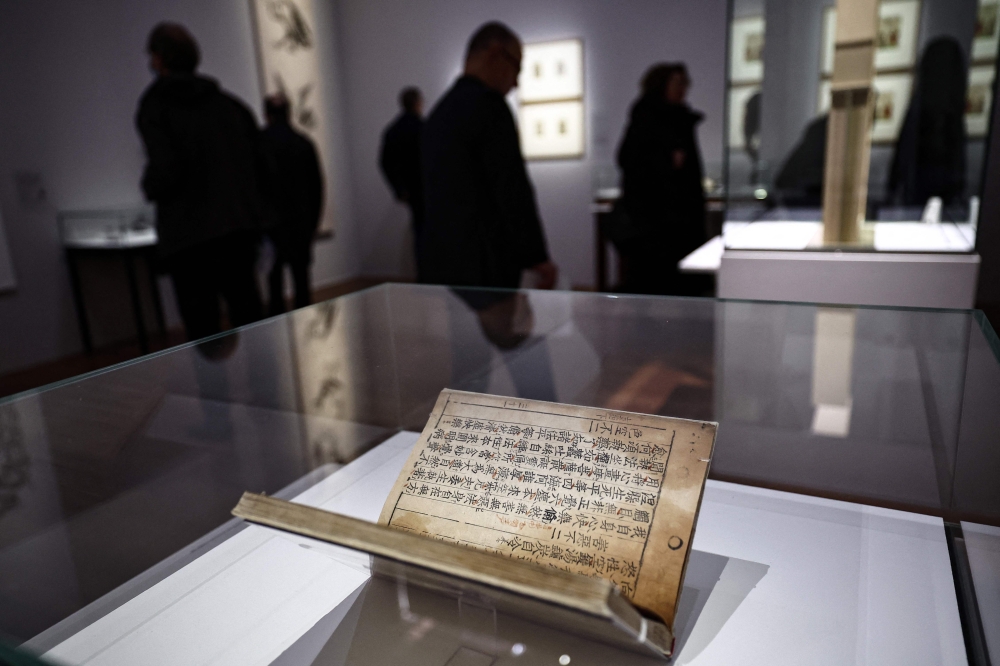 Visitors walks past the Jikji, a Korean book dating from 1377 and 