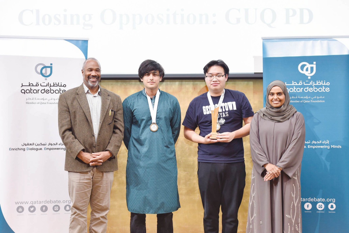 Representatives of the Georgetown Debating Union at Georgetown University in Qatar with the medals and trophy.
