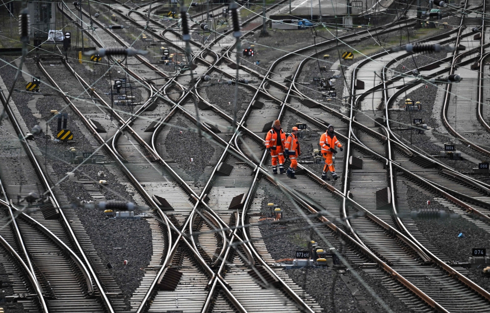 In this file photo taken on March 24, 2023 workers walk on train tracks of German railway operator Deutsche Bahn at the main railway station in Hagen, western Germany. Photo by INA FASSBENDER / AFP