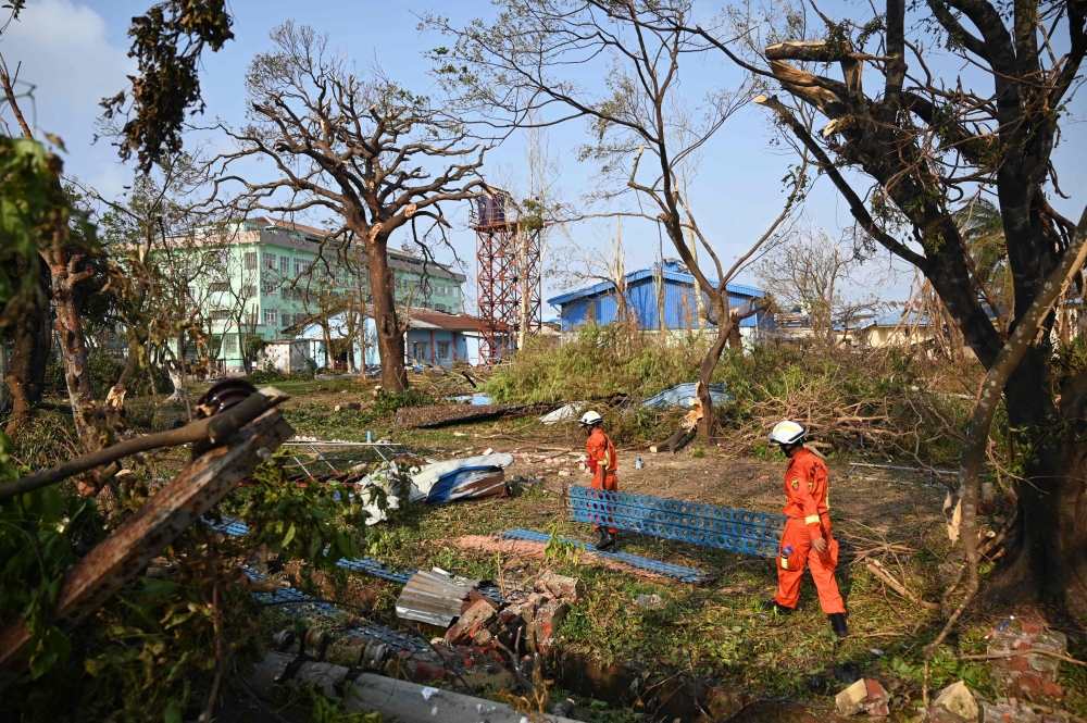 :Members of a rescue team clean up fallen trees in Sittwe on May 17, 2023, in the aftermath of Cyclone Mocha's landfall. (Photo by SAI Aung MAIN / AFP)
