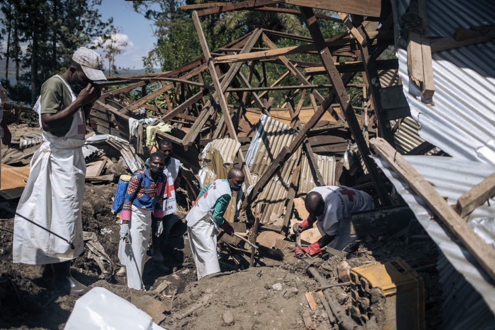 Local Red Cross volunteers attempt to extract a corpse from the rubble of a house destroyed by a landslide in the village of Bushushu in Kalehe Territory, South Kivu Province, eastern Democratic Republic of Congo on June 9, 2023. (Photo by Alexis Huguet / AFP)
