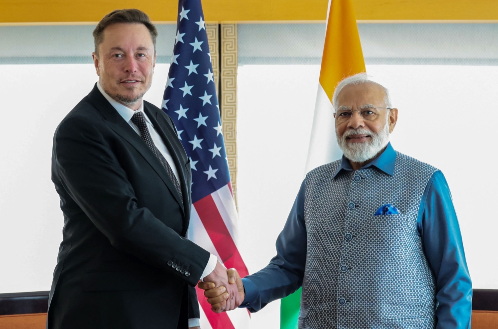 This handout photograph taken on June 20, 2023 and released by the Indian Press Information Bureau (PIB) shows India's Prime Minister Narendra (R) shaking hands with SpaceX, Twitter and electric car maker Tesla CEO Elon Musk during their meeting in New York. Photo by PIB / AFP