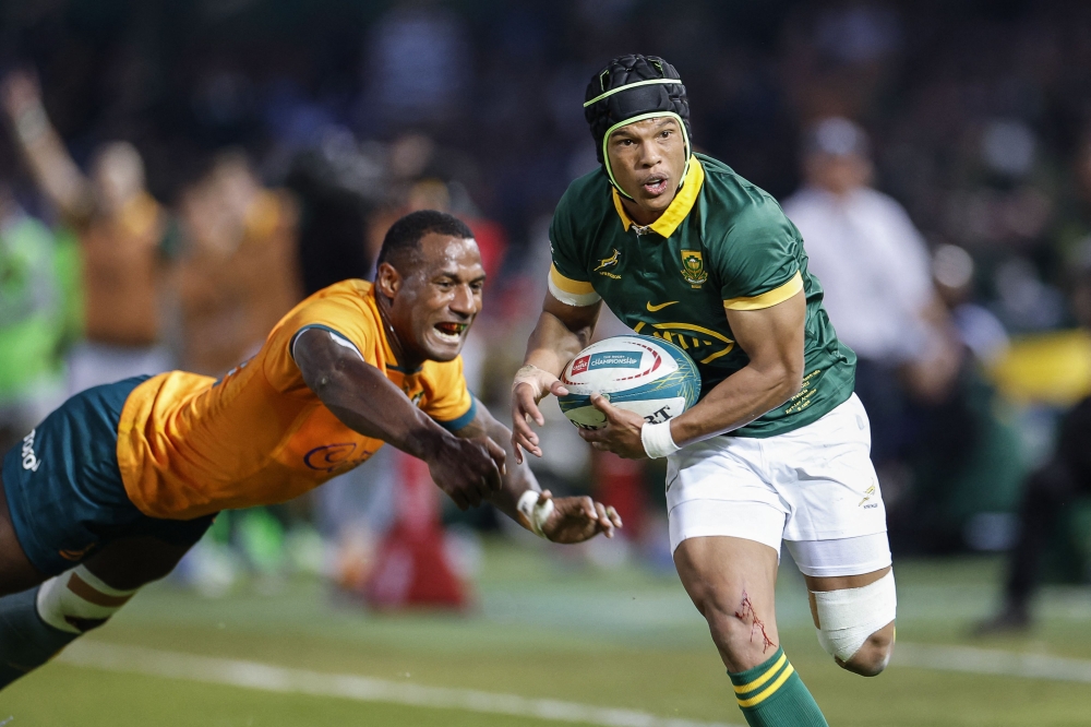 South Africa's wing Kurt-Lee Arendse (R) evades Australia's wing Suliasi Vunivalu as he runs to score a try during the Rugby Championship first round match between South Africa and Australia at Loftus Versfeld stadium in Pretoria on July 8, 2023. (Photo by WIKUS DE WET / AFP)
