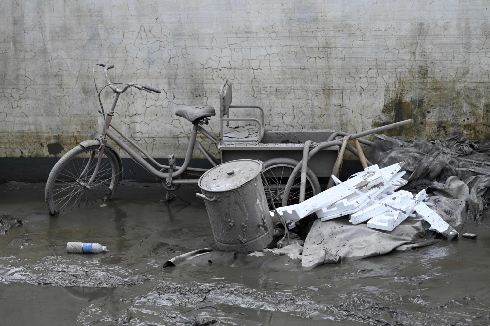 A tricycle covered with mud is seen by a villager house in the aftermath of flooding from heavy rains in Zhuozhou city, in northern China Hebei province on August 9, 2023. Photo by Jade Gao / AFP