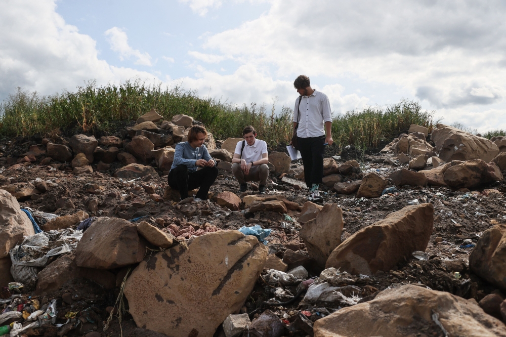 Environmental activists (L-R) Egor Chastukhin, Alexei Zetkin and Yakov Demidov inspect a landfill on the outskirts of Penza on August 22, 2023. (Photo by Olesya Kurpyayeva / AFP)
