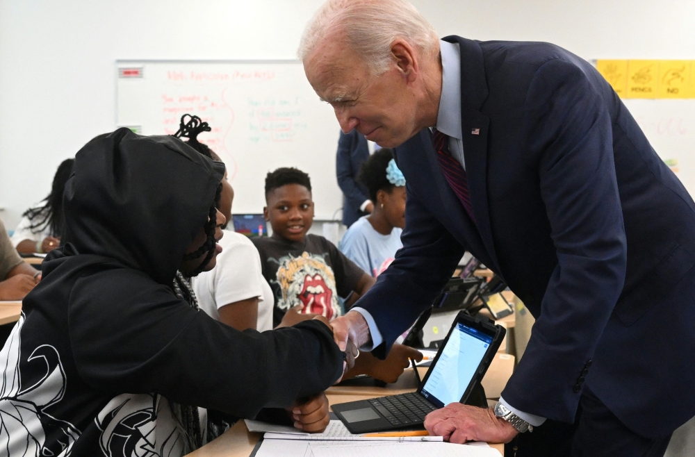 US President Joe Biden speaks with students as he and US First Lady Jill Biden welcome students back to school while visiting Eliot-Hine Middle School in Washington, DC, on August 28, 2023. (Photo by Saul Loeb / AFP)