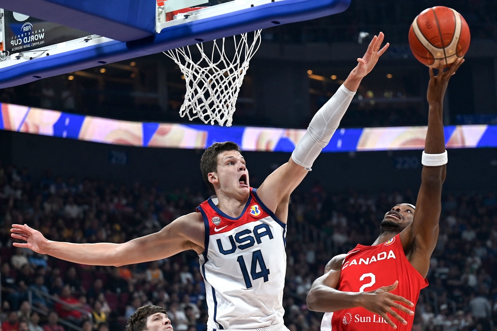 USA's Walker Kessler (L) tries to block Canada's Shai Gilgeous-Alexander (R) during the FIBA Basketball World Cup in Manila on September 10, 2023. (Photo by JAM STA ROSA / AFP)
