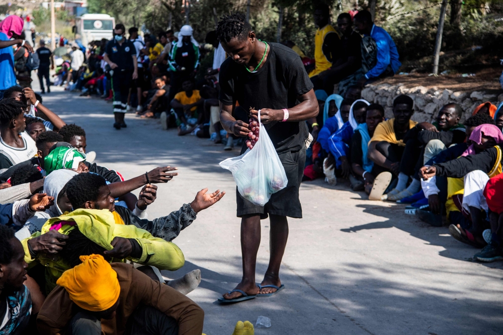 File photo: Migrants gather outside the operational centre called 