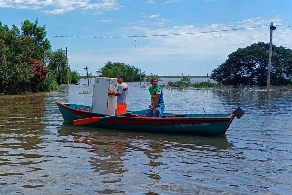Handout picture released by Argentina's Social Development via Telam showing locals using boats to move around and salvage belongings in Santo Tome, Corrientes Province, Argentina, on the border with Brazil, on November 6, 2023. (Photo by Argentina's Social Development Ministry / AFP) 