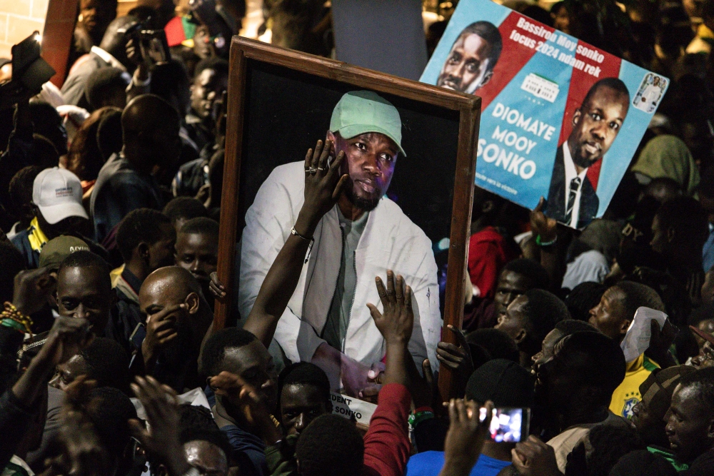 Supporters of Senegalese opposition leader Ousmane Sonko and presidential candidate Bassirou Diomaye Faye celebrate after the two men were released from prison, in Dakar on March 14, 2024. (Photo by JOHN WESSELS / AFP)
