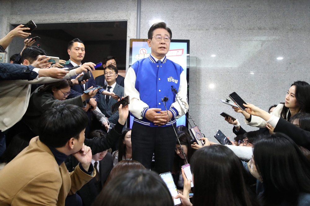 South Korea's main opposition Democratic Party (DP) leader Lee Jae-myung speaks to reporters after watching TVs broadcasting the results of exit polls for the parliamentary election at the National Assembly in Seoul on April 10, 2024. (Photo by Chung Sung-Jun / POOL / AFP)