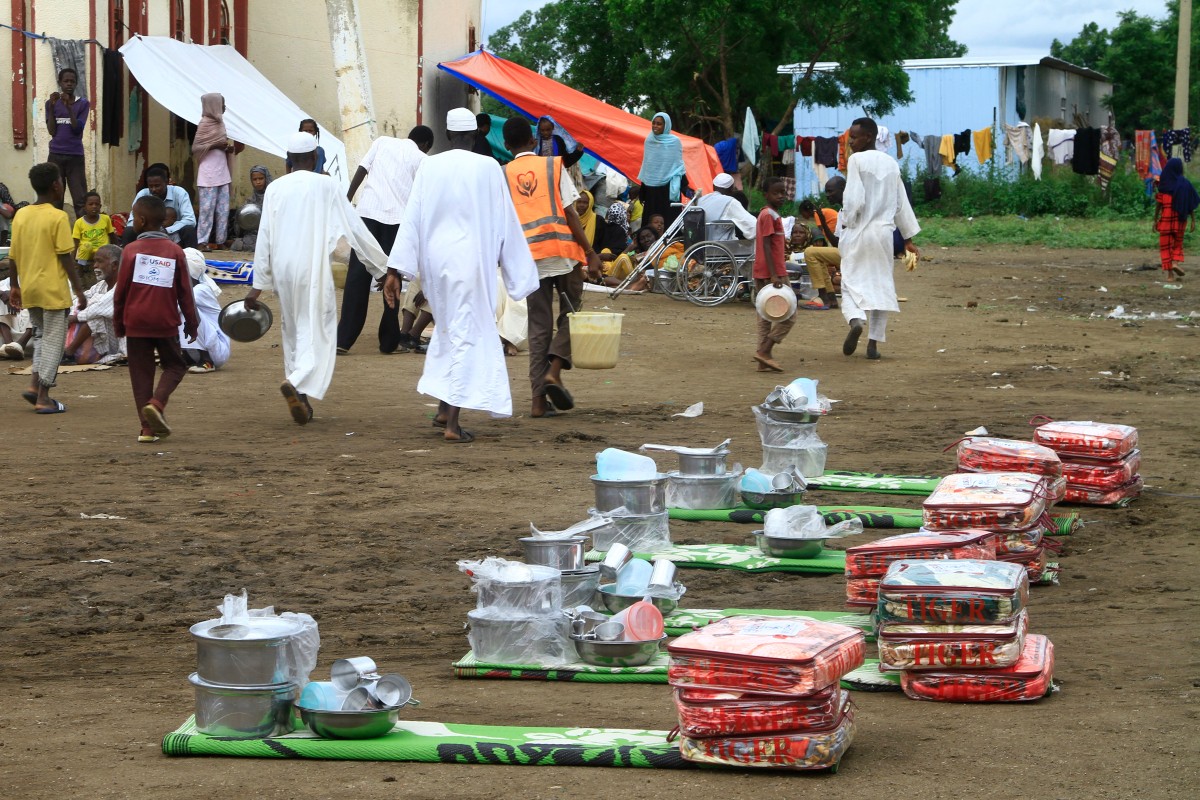 Sudanese, displaced from the town of Sinjah, receive humanitarian aid at their makeshift camp in the eastern city of Gedaref on August 22, 2024. (Photo by Ebrahim Hamid / AFP)
