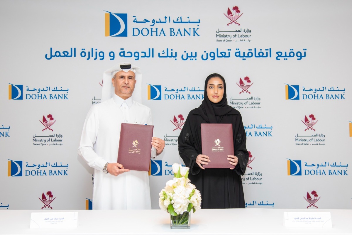 Assistant Undersecretary for National Manpower Affairs in the Private Sector at the Ministry of Labour Shaikha Abdulrahman Al Badi (right) and Chief Retail Banking Officer at Doha Bank Braik Ali Al Marri exchanging documents after signing the agreement.