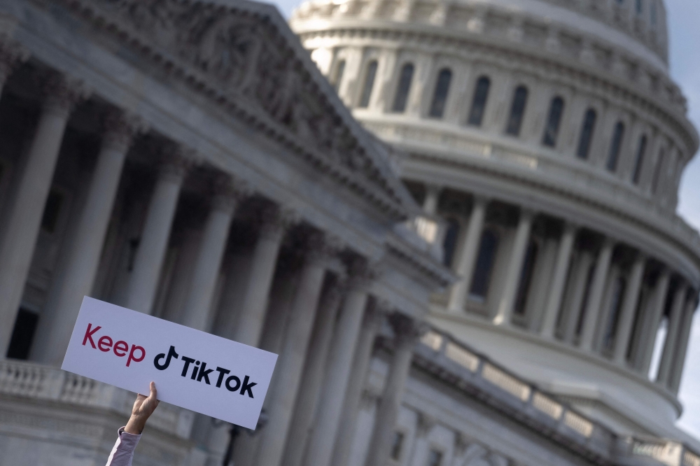 File: A person holds a sign during a press conference about their opposition to a TikTok ban on Capitol Hill in Washington, DC on March 22, 2023. (Photo by Brendan Smialowski / AFP)
