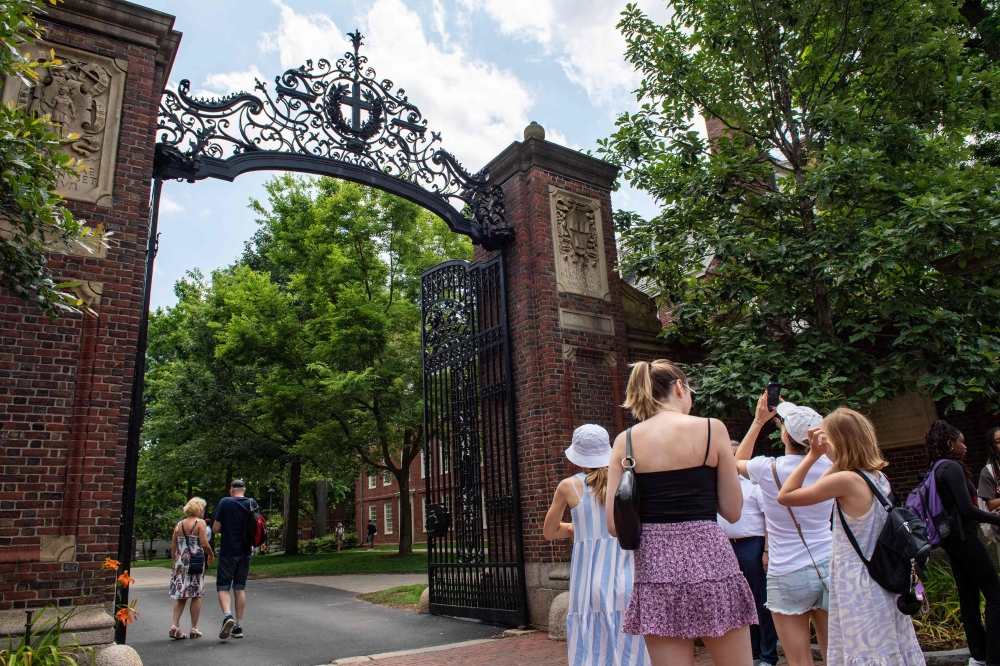 (Files) People take photos by the entrance to Harvard Yard in Cambridge, Massachusetts, on June 29, 2023. (Photo by Joseph Prezioso / AFP)
