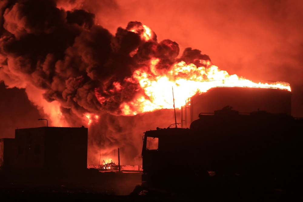 File: A giant fire erupts at an oil storage facility following Israeli strikes in Yemen's port city of Hodeida on July 20, 2024. (Photo by AFP)


