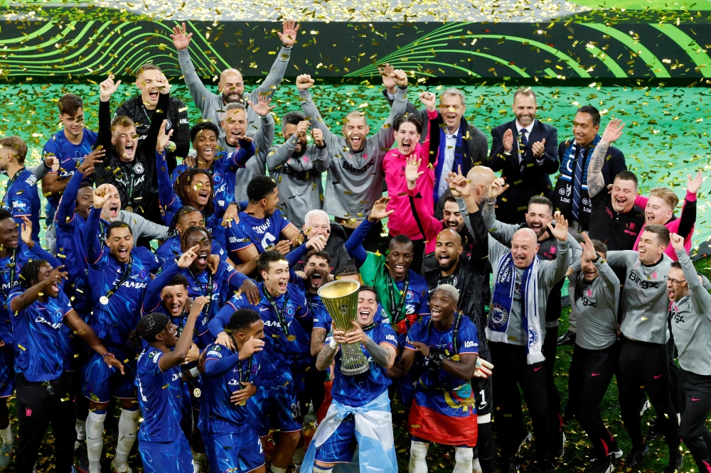 Chelsea's players and team members celebrate with the trophy during the awarding ceremony after winning the UEFA Conference League final football match between Real Betis and Chelsea FC in Wroclaw on May 28, 2025. (Photo by Wojtek RADWANSKI / AFP)