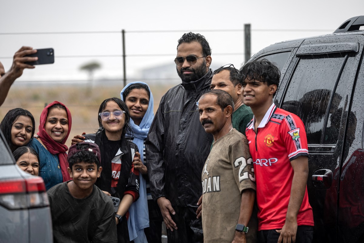 People take a selfie with Muhammed Sajjad, known locally as