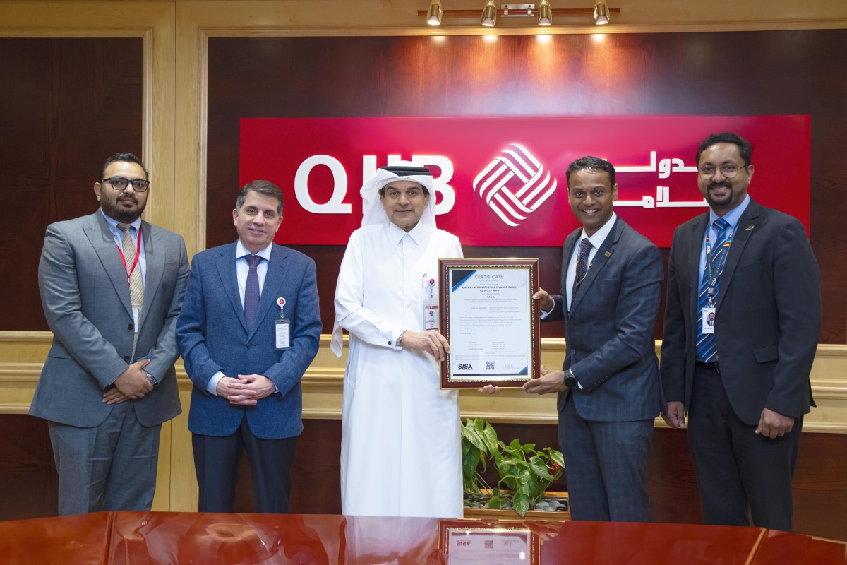 CEO of QIIB Dr. Abdulbasit Ahmed Al-Shaibei with other officials receiving the certification at the bank's headquarters at Grand Hamad Street.