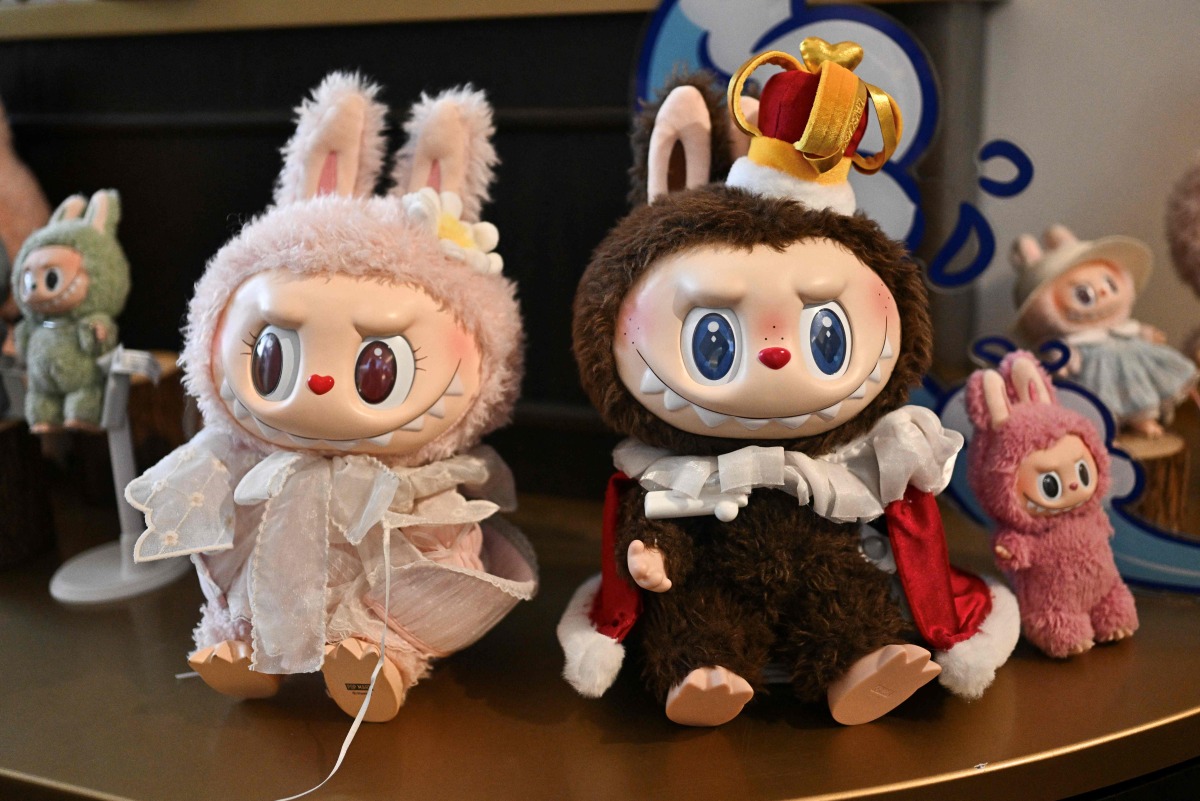 This picture taken on June 18, 2025 shows figures of the characters Mokoko and Labubu in an exhibition room at Pop Mart's theme park Pop Land in Beijing. (Photo by Pedro Pardo / AFP)

