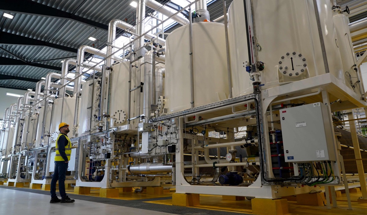 A worker looks at a row of machinery in Everfuel's new HySynergy electrolysis plant in Fredericia, Denmark, on November 3, 2025. Photo by James BROOKS / AFP
