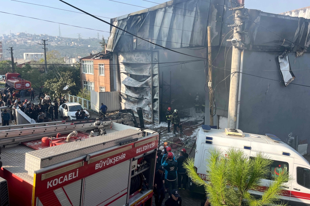 Rescuers and firefighters working at the site of a perfume warehouse where a fire broke out in the Dilovasi district of Kocaeli. Photo by Handout / DHA-Demiroren News Agency / AFP