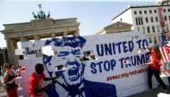 Campaigners pose on a 'United To Stop Trump' cardboard wall in front of the Brandenburg Gate to urge Americans living abroad to register and vote in Berlin, Germany, September 23, 2016. REUTERS/Axel Schmidt
