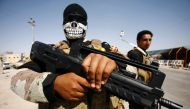 Members of the Popular Mobilisation Units supporting the government forces stand on the outskirts of the holy Iraqi city of Najaf on September 24, 2016, as take part in a military parade from Karbala to Najaf to review the military equipment to be used in