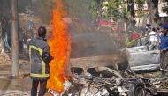 Firefighters douse the flaming wreckage of car after a suicide car bomb attack in Mogadishu on October, 1, 2016. AFP / Mohamed ABDIWAHAB