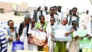 Residents of eastern Sudan receiving aid packets from Qatar Charity officials.