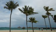 People walk along a beach in the wind in advance of Hurricane Matthew in Nassau, Bahamas October 5, 2016. REUTERS/Carlo Allegri
