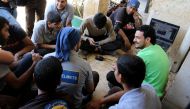 Civil Defence members, also known as the 'White Helmets', who have been nominated for the 2016 Nobel Peace Prize, gather around a laptop as they wait the announcemenet of the winner, in a rebel held area of Aleppo, Syria October 7, 2016. REUTERS/Abdalrhma