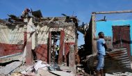 Men salvage metal sheets from a destroyed house after Hurricane Matthew passes in Jeremie, Haiti, October 8, 2016. REUTERS/Carlos Garcia Rawlins
