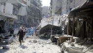 A civil defence member runs at a market hit by air strikes in Aleppo's rebel-held al-Fardous district, Syria October 12, 2016. REUTERS/Abdalrhman Ismail