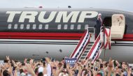 Republican presidential nominee Donald Trump pumps his fist to supporters at the conclusion of his campaign event on the tarmac at Lakeland Linder Regional Airport in Lakeland, Florida on October 12, 2016. / AFP / Gregg Newton
