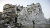 Members of the Syrian Civil Defence, known as the White Helmets, search for victims amid the rubble of a destroyed building following reported air strikes in the rebel-held Qatarji neighbourhood of the northern city of Aleppo, on October 17, 2016.  AFP / 