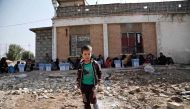 A handout picture release by Save The Children shows Ali, a five-year-old displaced Iraqi boy playing as they wait to be screened at the Dibis checkpoint northwest of the northern Iraqi city of Kirkuk on October 16, 2016 after they fled the Islamic State 