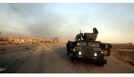 Smoke rises from a building as Iraqi soldiers take positions after retaking of Bartilla Town from Islamic State members during the operation to retake Iraq's Mosul, October 20, 2016.  Ali Mohammed - Anadolu Agency
