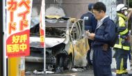 Policemen and firefighters investigate a parking lot after an explosion in Utsunomiya, where one person was found dead after blasts in a park. Photograph: Jiji Press/AFP/Getty Images