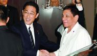 Philippines' President Rodrigo Duterte (R) is welcomed by Japanese Foreign Minister Fumio Kishida (L) prior to their dinner meeting at the entrance of a Japanese restaurant in Tokyo on October 25, 2016. Duterte is here on a three day visit. (AFP / TOSHIFU