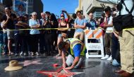 This file photo taken on October 26, 2016 shows a crowd as it gathers to watch as Donald Trump's vandalized Star along the Hollywood Walk of Fame is repaired before being replaced on October 26, 2016 in Hollywood, California. (AFP / Frederic J. BROWN)