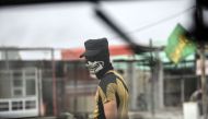 A member of Iraqi forces, wearing a skull mask, waits at a checkpoint for people fleeing the main hub city of Mosul on October 28, 2016 between Qayyarah and Mosul during an operation to retake the city from the Islamic State (IS) group. AFP / BULENT KILIC