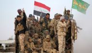 Shiite fighters from the Hashed al-Shaabi (Popular Mobilisation) flash the sign of victory from the back of a truck as they drive towards the village of Umm Sijan, south of Mosul, on October 31, 2016 during Iraqi forces' operation to recapture the main hu