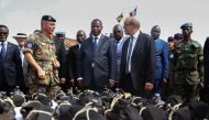 French Defence Minister Jean-Yves Le Drian (C) flanked by President of the Central African Republic Faustin-Archange Touadera (2ndL), looks at military supplies at the Mpoko military base in Bangui on October 31, 2016. France on October 31, 2016 formally 