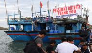 A Vietnamese fisherman (2nd R, facing camera) hugs a Filipino government employee (C, in white shirt) during a send-off ceremony at the wharf in Sual town, Pangasinan province, north of Manila on November 2, 2016, while other Vietnamese fishermen prepare 