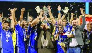 Iraq's Air Force Club coach Basim Qasim Hamdan Al Suwaid (centre) raises the trophy as he celebrates on the podium with his team after beating India's Bengaluru FC to win the AFC Asian Cup football final at the Qatar Sports Club Stadium in Doha, yesterday