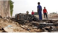 Iraqi youth gather by wreckage at the site of a car bomb that exploded the previous night in Baghdad's Hurriyah neighbourhood on October 31, 2016. (AFP)