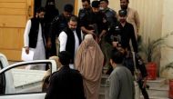 Policemen escort Sharbat Gula (C), the green-eyed Afghan woman who became a symbol of her country's wars 30 years ago when her photo as a girl appeared on the cover of National Geographic magazine, as she leaves after appearing before a court in Peshawar,