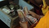 An Indian railway counter cashier counts 1000 and 500 rupee notes at Allahabad Railway station in Allahabad on November 9, 2016. India's government tried to quell the panic caused by a bombshell decision to withdraw 500 and 1,000 rupee notes from circulat