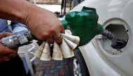 A worker fills diesel in a car as he holds 500 Indian rupee banknotes at a fuel station in Kolkata, India, November 9, 2016. REUTERS/Rupak De Chowdhuri